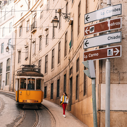 Lisbon, Portugal - 27 January, 2019 - girl walk on Lisbon street. famous yellow tram. Lifestyle and travel concept.