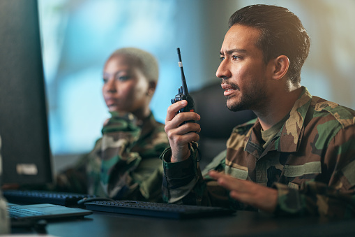 Walkie talkie, communication and military team at the station with computer giving directions. Technology, collaboration and soldiers in army room or subdivision with radio devices for war contact.