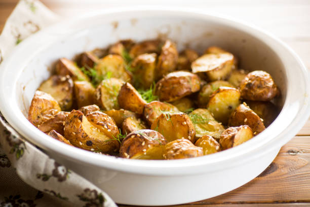 patatas horneadas con semillas de sésamo, hierbas y especias en el horno - roasted potatoes prepared potato herb food fotografías e imágenes de stock