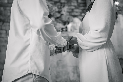 Couple hands. Engagement ring. Man holds woman's hands in hands. Propose. Offer of hand and heart. Man making a marriage proposal to female. Engaged couple in love closeup. Black and white photo.