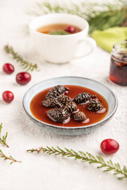istock Pine cone jam with herbal tea on gray concrete, side view, selective focus. 1567271838
