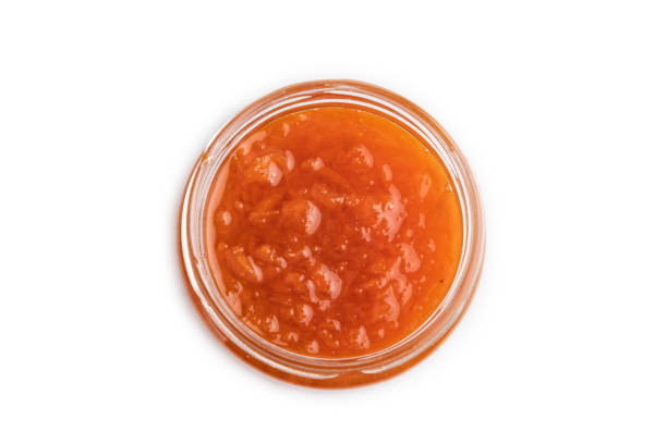 istock Carrot jam with cinnamon in glass jar isolated on white. Top view. 1567273162