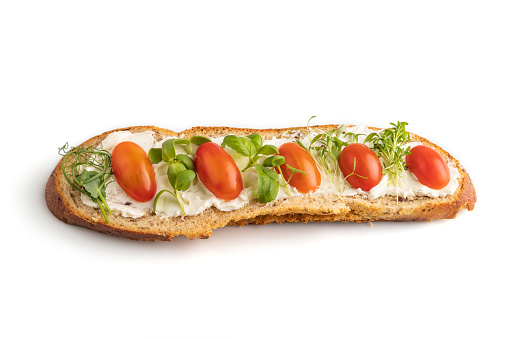 Long white bread sandwich with cream cheese, tomatoes and microgreen isolated on white background. side view, close up.