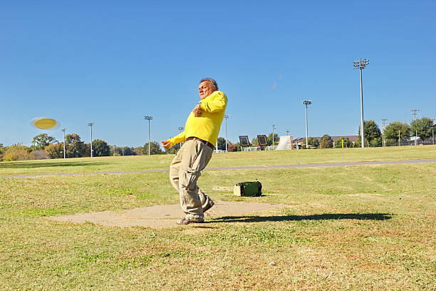 Mature Male Keeping Active with Disc Golf on Sunny Afternoon stock photo