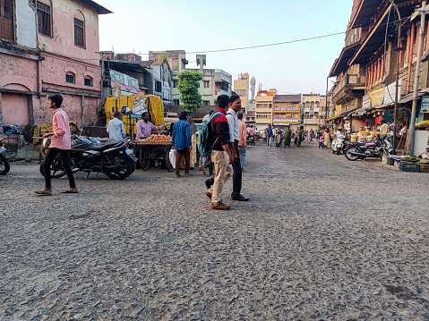 Kolhapur,India- November 6th 2022; Stock photo of Kolhapur Municipal Corporation building, small commercial shop at the ground floor, street vendor near the budding. people and vehicle moving on road
