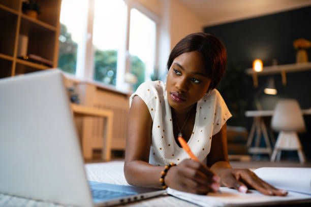 istock Young woman of Black ethnicity studying while lying on the floor 1567289468