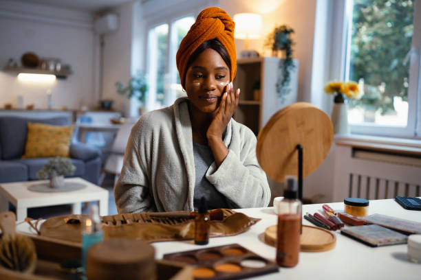 istock Young woman of Black ethnicity, applying moisturizer 1567296301