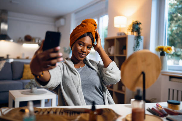 istock Woman of Black ethnicity, taking selfie, while doing a skin care routine 1567297401