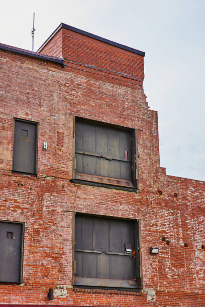 istock Abandoned brick building with old freight elevator doors leading to open air 1567302428
