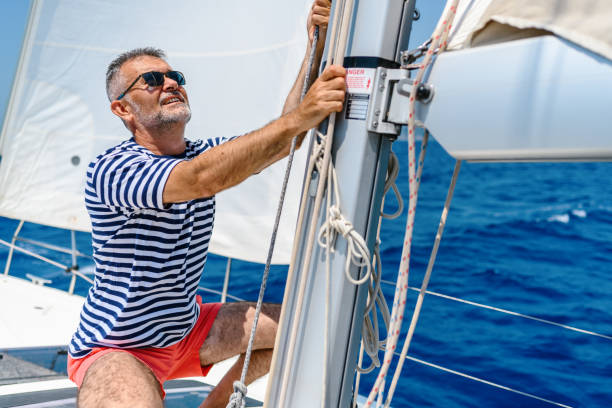 istock Mature man on sailboat 1567302992