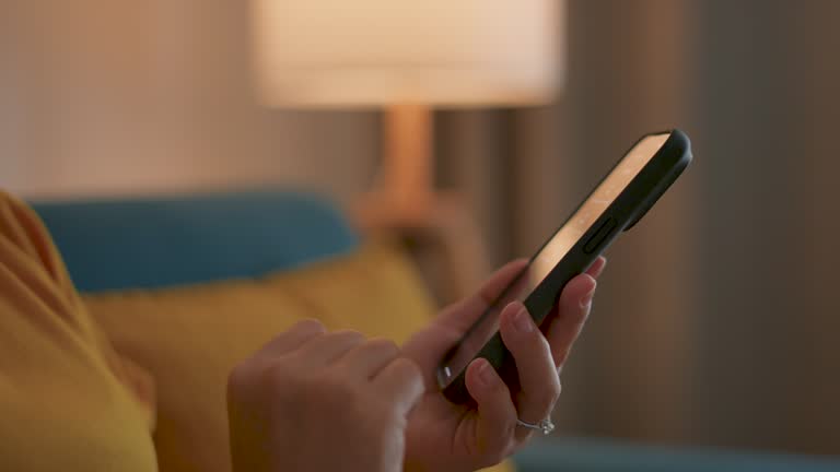 Close-up shot of female's hands using smart phone for turn on the lights.