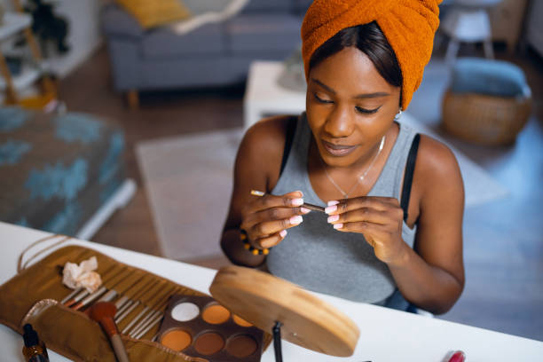 istock Woman of Black ethnicity applying a lip liner while doing her make up 1567310305