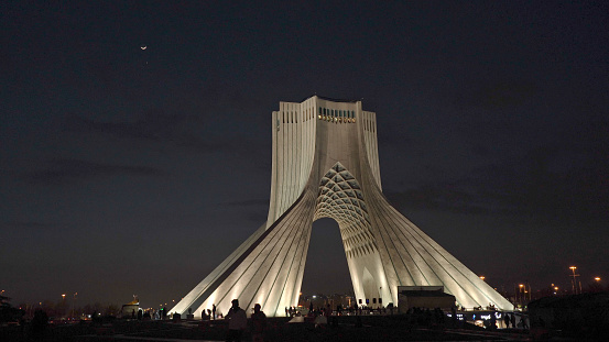 Azadi Tower at Night with a slender moon crescent in the sky in Tehran, Iran