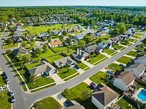 Image of Aerial neighborhood with bright green summer lawns