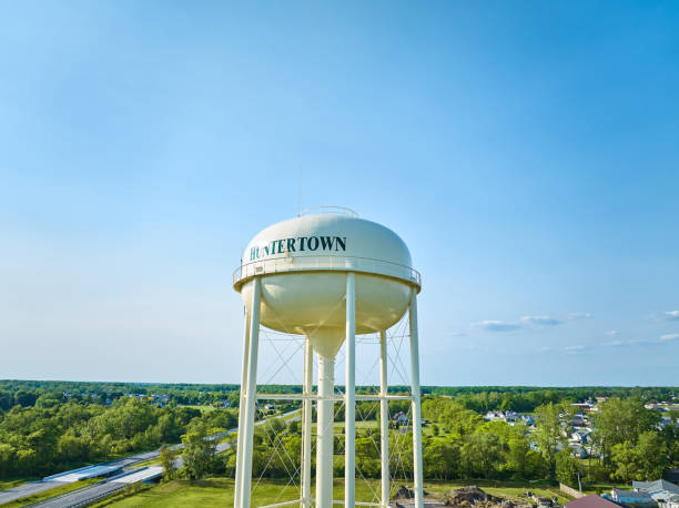 istock Aerial white Huntertown water tower with distant green trees and blue sky 1567324127