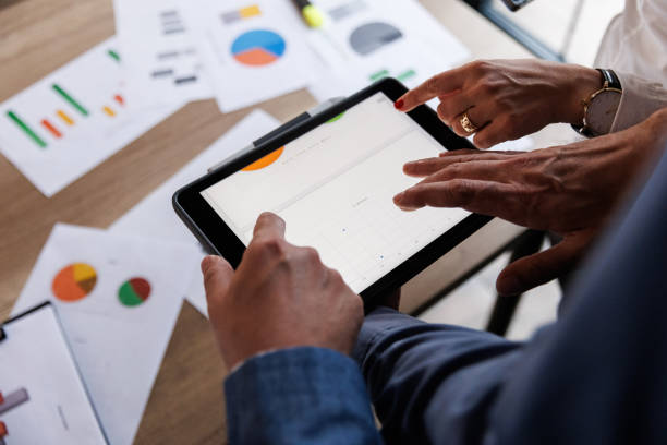 istock Businessman scrolling through various data on digital tablet during a meeting 1567328684
