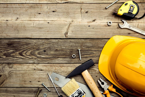 istock Construction tools with safety helmet on wooden background. Happy Labor day banner design. 1567331472