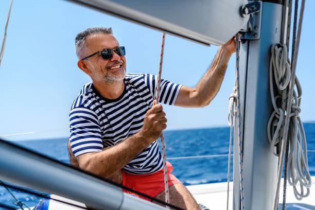 istock Mature man on sailboat 1567333398