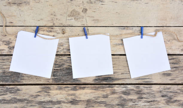 Empty white paper notes on a wooden background stock photo