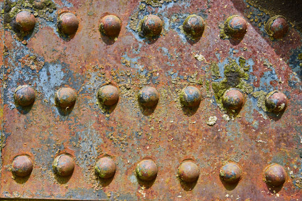 istock Colorful background asset rusting metal rivets with flaking yellow bits and blue iron patches 1567347829