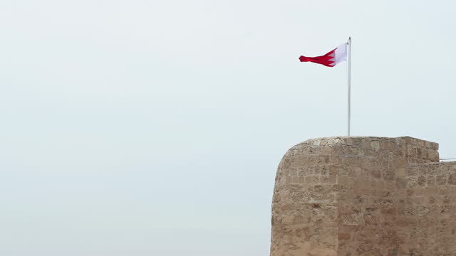 Bahrain Flag fortress on sky background in Manama, Unesco world heritage site.