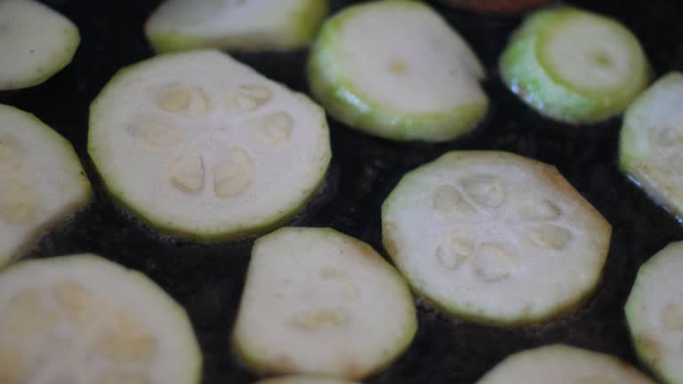 close-up of cooking in a frying pan in oil slices of zucchini, eggplant. vegetable diet, fried zucchini round pieces.