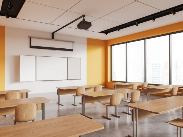 istock Bright classroom interior with table in row and blackboard with screen, window 1567375638