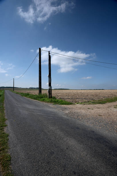 Overland electricity line with poles Ancient overland line for transportation of electricity in rural environment in Touraine horizon over land stock pictures, royalty-free photos & images