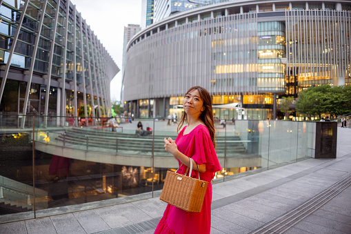 Woman in pink dress walking in urban city