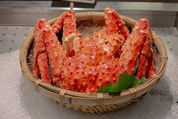 Photo of Red fresh steamed boil king crab leg from sea for delicious tasty seafood meal in store market restaurant, orange alaskan claw raw luxury crustacean animal for healthy gourmet in Japanese Asia pacific