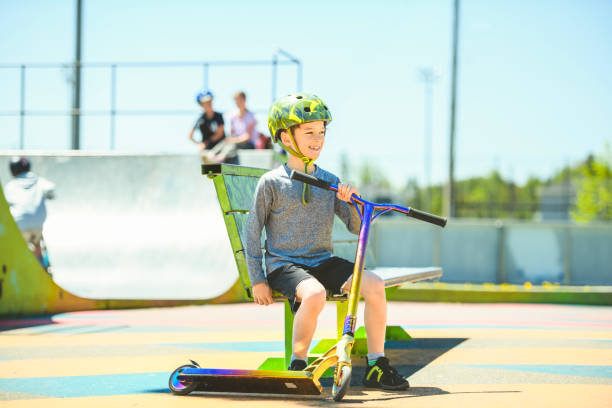 istock boy with helmet riding his scooter on a sunny day 1567410925