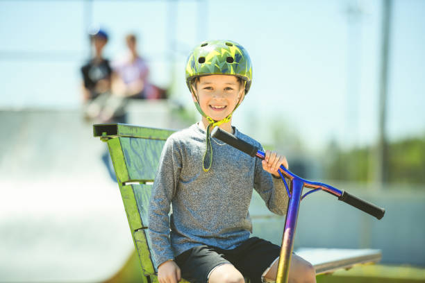 istock boy with helmet riding his scooter on a sunny day 1567410930