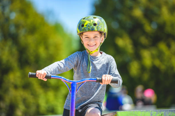 istock boy with helmet riding his scooter on a sunny day 1567410934