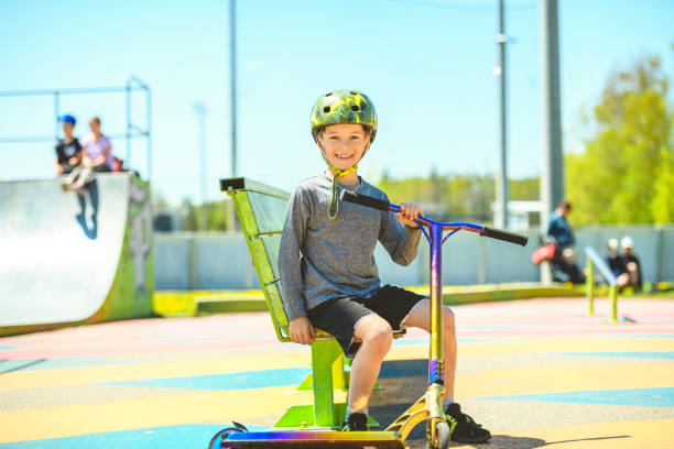 istock boy with helmet riding his scooter on a sunny day 1567410936