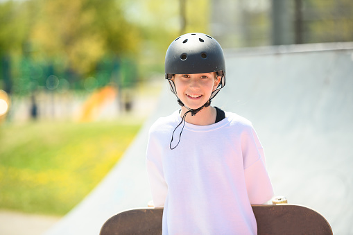 A child girl playing skate or skateboard at parking to wearing safety helmet