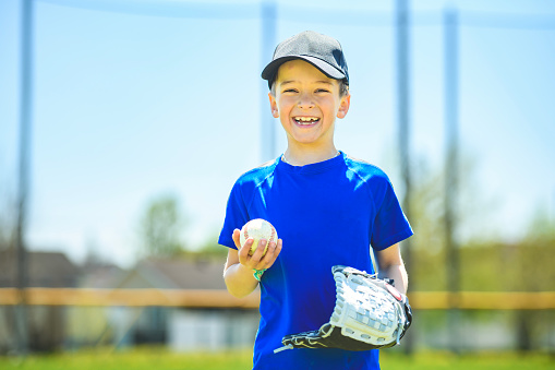 A Young boy play baseball on summer day