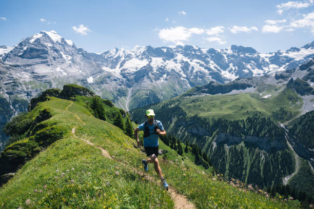 trail runner ascends alpine path in swiss mountain landscape - switzerland cold green rock imagens e fotografias de stock