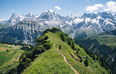 Trail runner ascends alpine path in Swiss mountain landscape