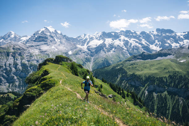 trail runner ascends alpine path in swiss mountain landscape - switzerland cold green rock imagens e fotografias de stock