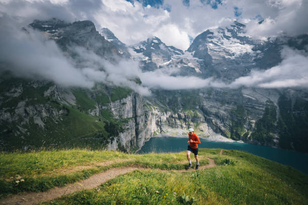 istock Trail runner ascends alpine path in Swiss mountain landscape 1567426988