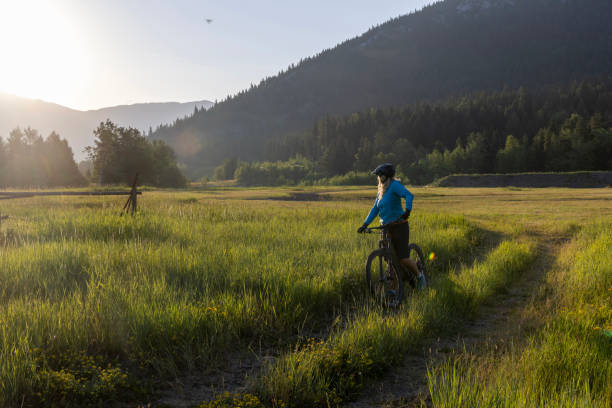 istock Senior female mountain biker pauses beside pathway 1567427400