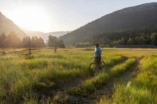 istock Senior female mountain biker pauses beside pathway 1567429065