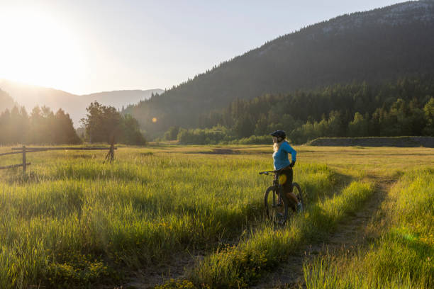 istock Senior female mountain biker pauses beside pathway 1567429067