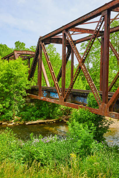 istock Old rusty train bride over Kokosing River in summer vertical 1567442147