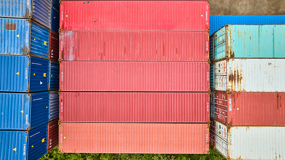 Image of Overhead downward view of pink pastel colored shipping containers in shipping yard aerial