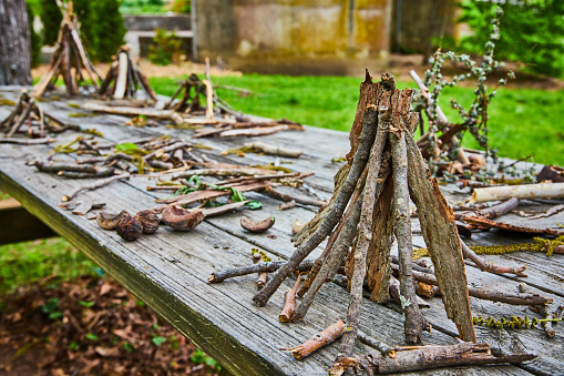 Image of Park background of picnic table covered in small stick teepee piles