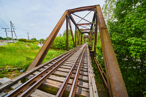 Image of Rusty truss iron railroad bridge with train tracks over Kokosing River in Mount Vernon Ohio