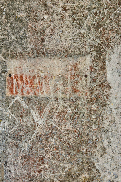 istock Scratched up concrete wall with rust and dirt stains corroding and marked up 1567459765