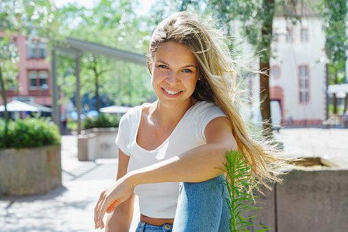 Beauty young woman with white teeth smiling in the street. Summertime