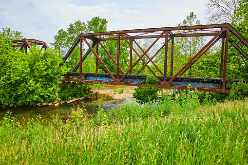 Image of Summer shot of Kokosing River with train bridge and field of grass